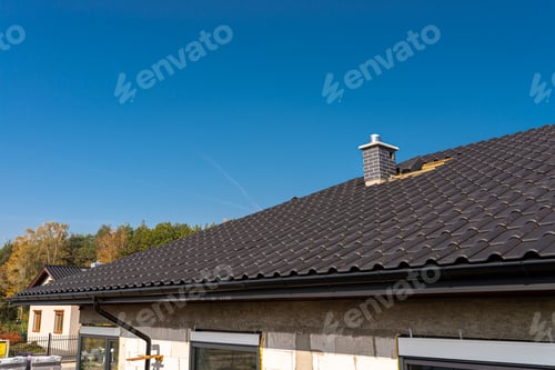 Preview: The roof of a single-family house covered with a new ceramic tile in anthracite, against the blue sk