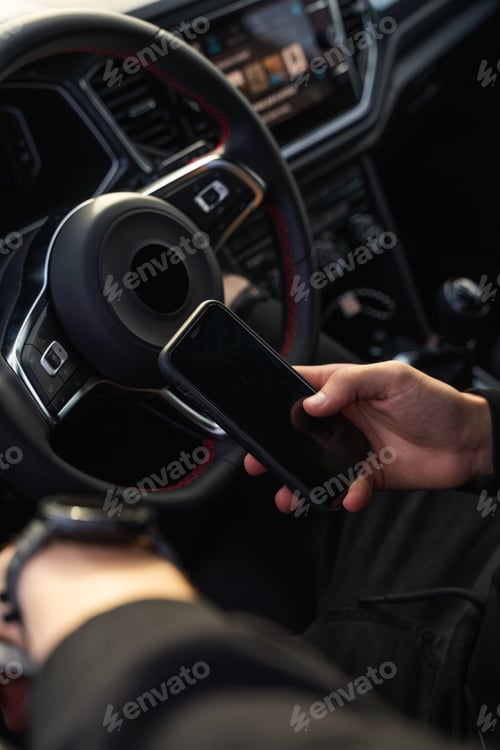 Preview: Unrecognizable man using mobile phone in car