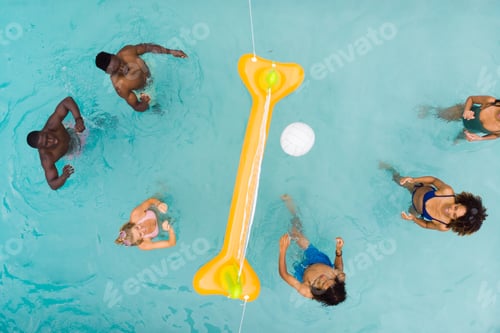 Preview: Overhead of happy diverse friends playing fun game of volleyball in sunny swimming pool, copy space