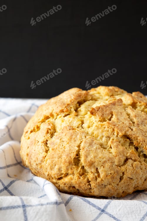 Preview: Homemade Irish Soda Bread on cloth, side view. Close-up.