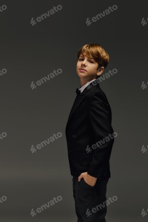 Preview: Elegantly dressed preteen boy showcasing timeless fashion in a studio setting