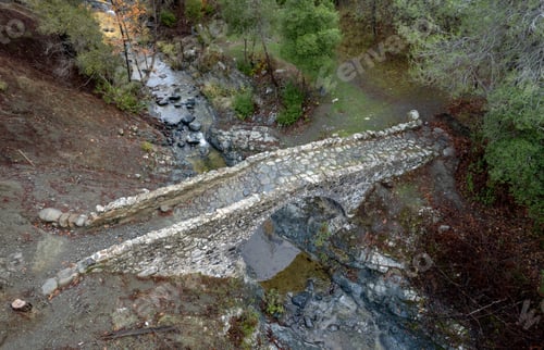 Preview: Drone aerial view of a medieval stoned bridge water flowing in the river in autumn