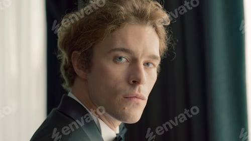 Preview: Attractive man in suit looks at camera. Action. Handsome man looks seriously at camera. Serious