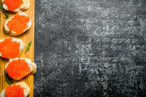 Preview: Sandwiches with red caviar on a wooden stand.