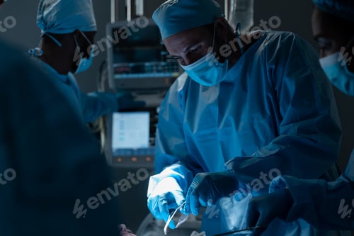 Preview: Caucasian male surgeon wearing face mask and protective clothing during operation in hospital