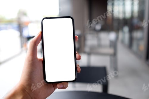 Preview: Mockup image of a man holding black mobile phone with blank white screen in cafe