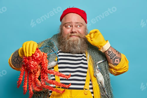 Preview: Cheerful seaman curls mustache, holds big sea creature, dressed in striped jumper and yellow overall