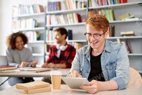 Preview: Smiling casual guy pointing at curious stuff on tablet display