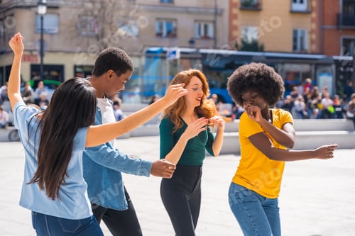 Preview: Multiethnic young friends dancing in the city, authentic group of diverse friends having fun