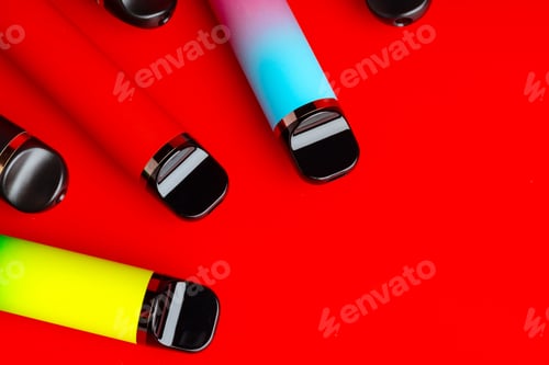 Preview: Colorful disposable electronic cigarettes on red background