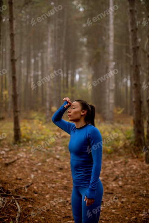 Preview: Young woman take a break during outdoor exercise on the forest trail at autumn