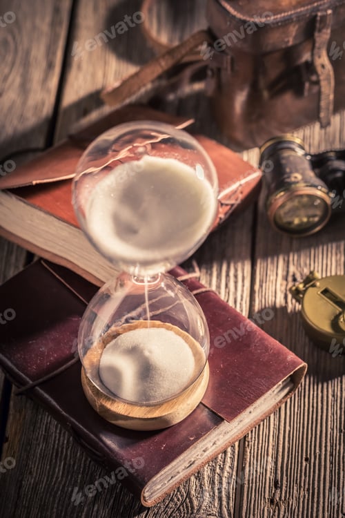 Preview: Vintage hourglass and journal as a concept of travel memories