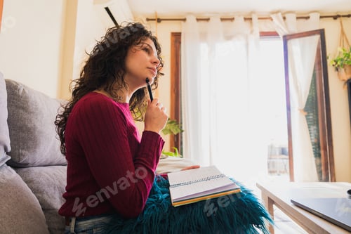 Preview: Young woman thinking, planning new ideas at home
