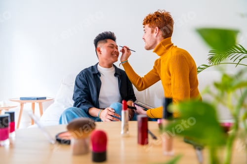 Preview: Beautiful gay couple doing makeup and having fun being romantic at home, lgbt concept