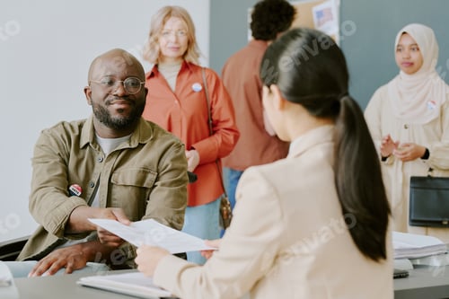 Preview: Polling Station Worker Giving Ballot Paper To Man With Disability
