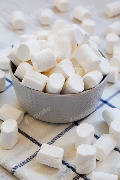 Preview: Sweet white marshmallows in a grey bowl, side view. Close-up.