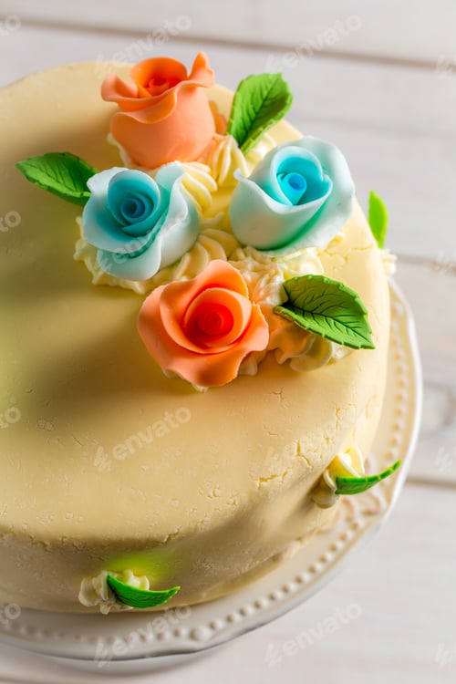 Preview: Sweet marzipan roses on the cake on old wooden table