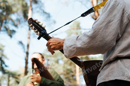 Preview: Musician playing ethnic guitar at outdoor entertainment, close-up. Musical folk group