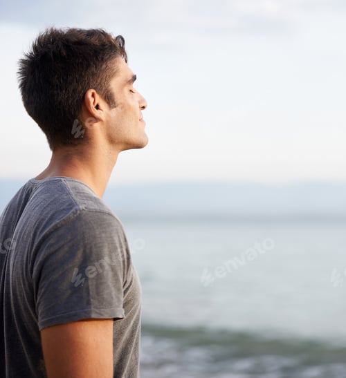 Preview: Taking in the fresh air. Cropped shot of a handsome young man on the beach.