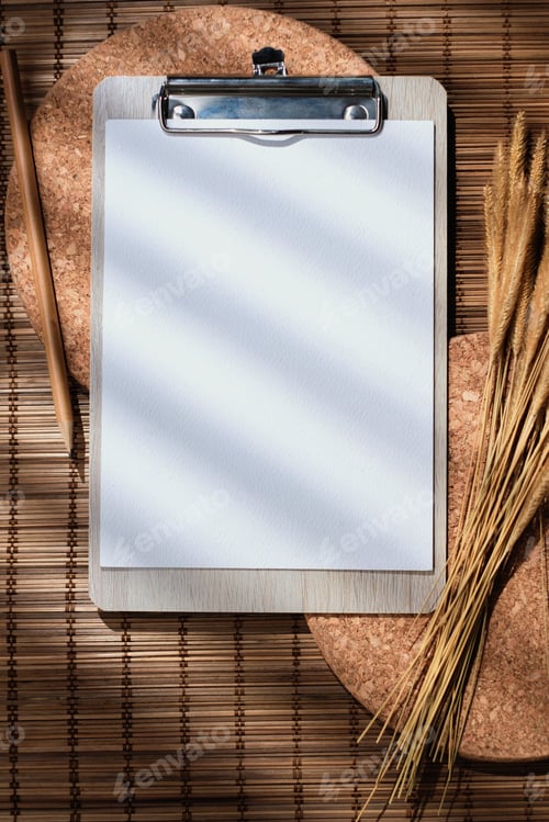 Preview: mockup blank clip paper board top view on wood mat table with morning sunlight