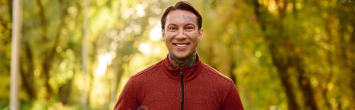 Preview: Handsome stylish man in vibrant park attire showcases modern fashion with confident smile