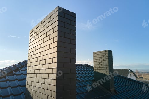 Preview: Closeup of brick chimney on house roof top covered with ceramic shingles. Tiled covering of building