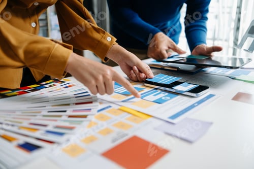 Preview: Close up view of UI developer team brainstorming on their project with laptop, smartphone