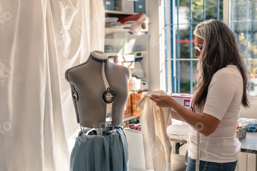 Preview: seamstress checking a piece of fabric to put it on a mannequin