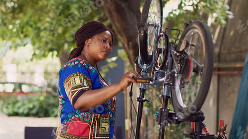Preview: Woman holding bike pedal for maintenance