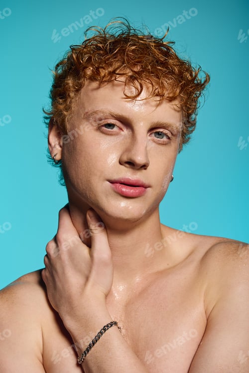 Preview: Stylish young man with curly hair poses confidently against a vibrant blue background
