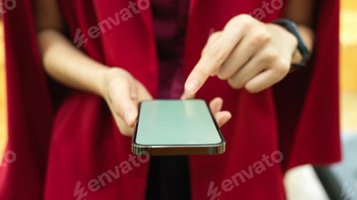 Preview: Elegant woman in red dress using apps on touchscreen smartphone
