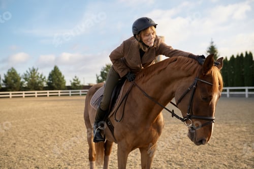 Preview: Female horse trainer with her stallion outdoors in farm