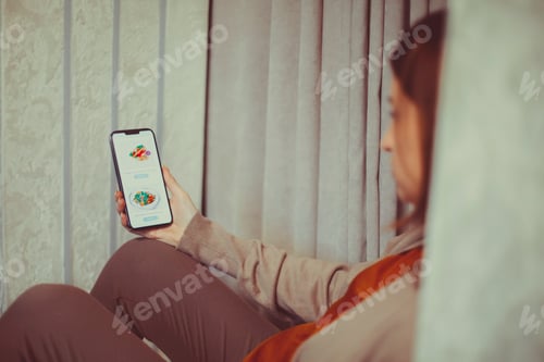 Preview: Pregnant woman holding smartphone using pregnancy tracker app on mobile phone while