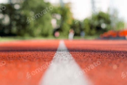 Preview: Outdoor stadium jogging track. Texture of red rubberized surface with a white line in the middle