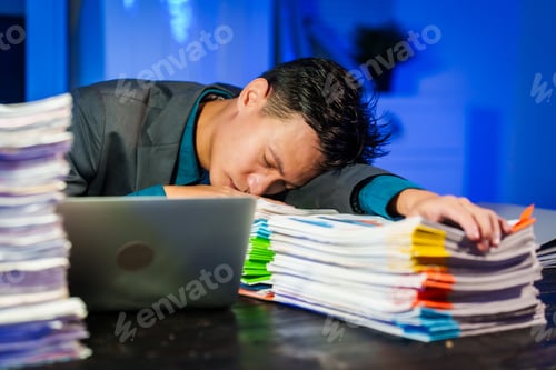 Preview: An Asian young businessman sit his desk late night,exhausted from overtime work.Resting his eyes
