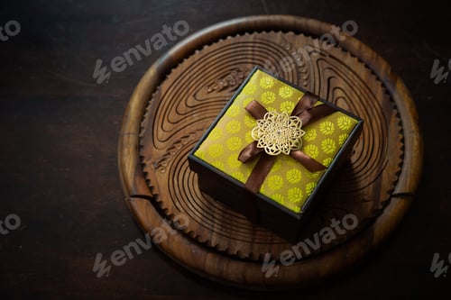 Preview: yellow songket box wrapped in ribbon on traditional handcrafted background
