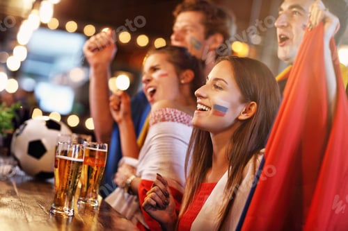 Preview: Group of friends watching soccer in pub