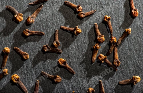 Preview: Dried Cloves on dark stone background. Natural hard light. Spice cloves close-up shot.