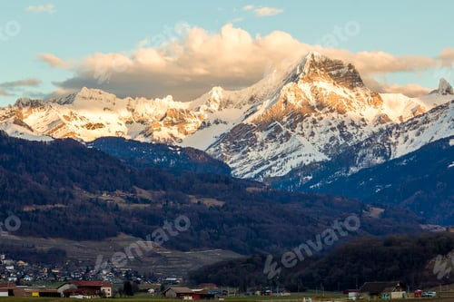 Preview: Small town at foot of magnificent Alps mountain range, Switzerland.