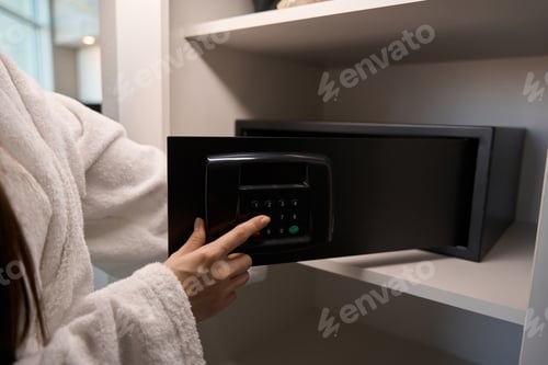 Preview: Woman in a fluffy terry bathrobe opens a portable safe