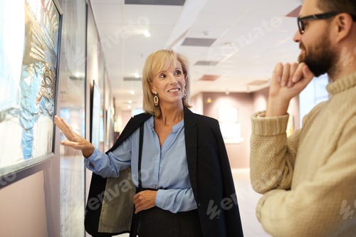 Preview: Smiling Woman Pointing at Painting in Art Gallery