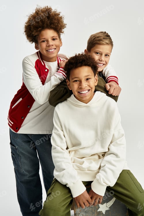 Preview: Three cheerful boys share a joyful moment in colorful outfits showcasing their friendship