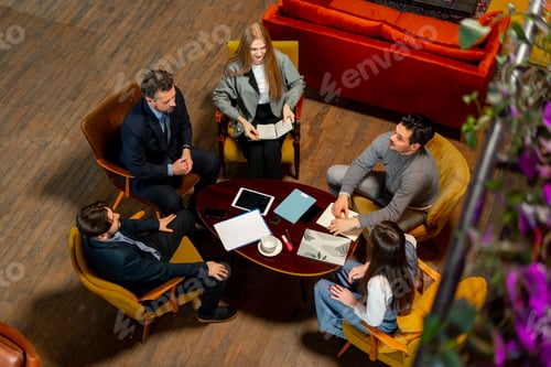 Preview: top shot in large beautiful hall office employees sitting on yellow chairs discuss a deal