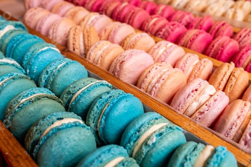 Preview: High-angle view of trays of colorful macarons displayed on a wooden stand