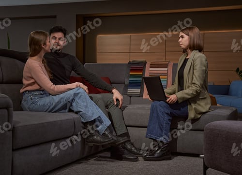 Preview: Buyers seated in furniture shop before saleslady