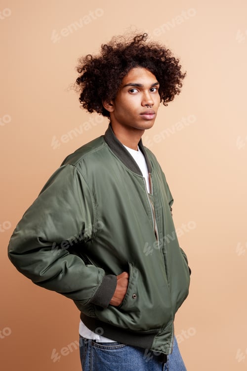 Preview: Pensive, serious African American young man with piercing in nose wearing stylish green jacket