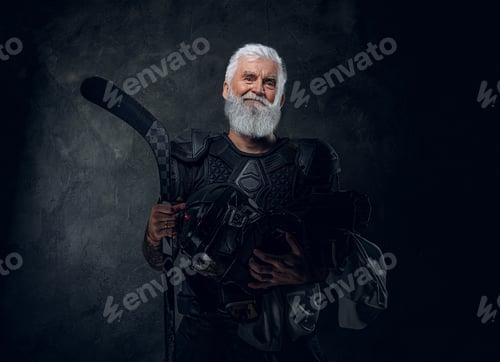 Preview: Joyful old man athlete with hockey stick against dark background