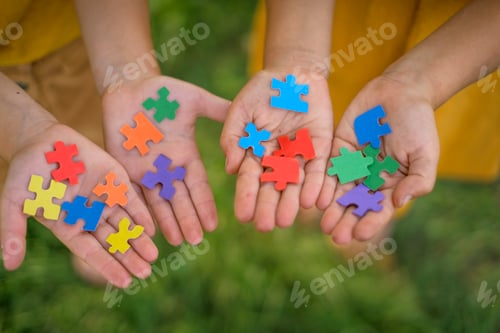 Preview: Multicolor paper puzzles in the hands of children.
