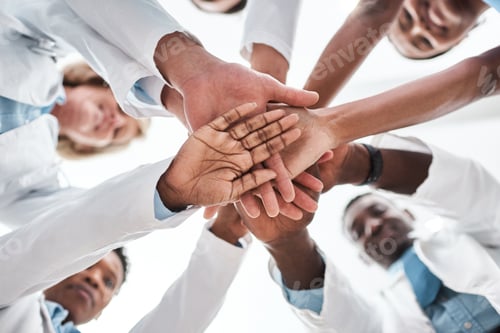 Preview: Closeup shot of a group of medical practitioners joining their hands together in a huddle
