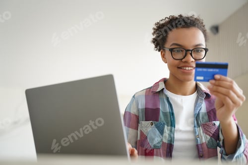 Preview: Online payment, money transfer. Handsome afro girl is buying online with credit card.